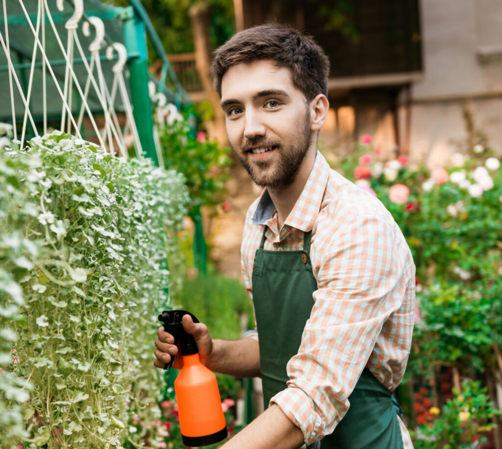 Cheerful gardener watering plants